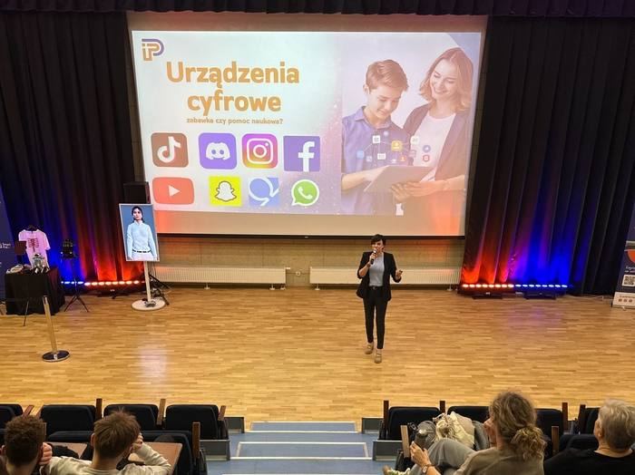Wykład dla uczniów w auli o urządzeniach cyfrowych