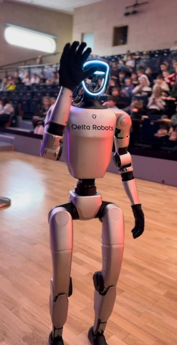 Robot humanoidalny G1 macha do uczniów na widowni